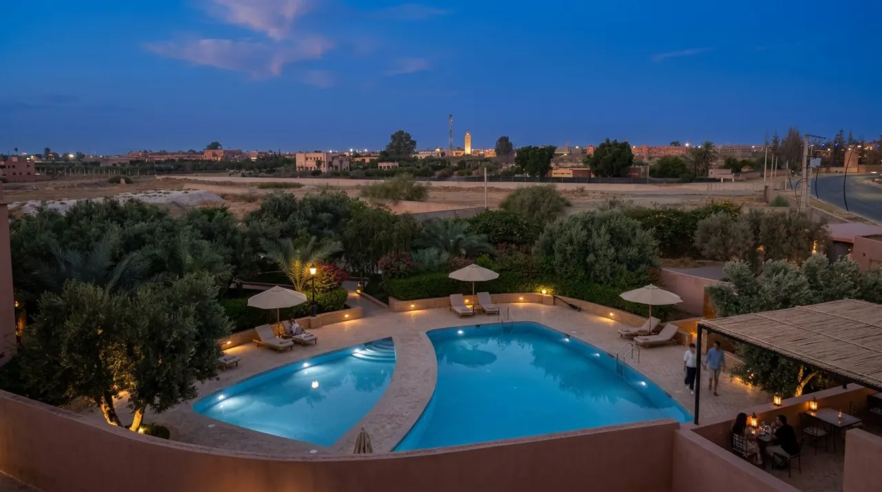 Swimming pool at dusk with lounge chairs and Moorish architecture behind